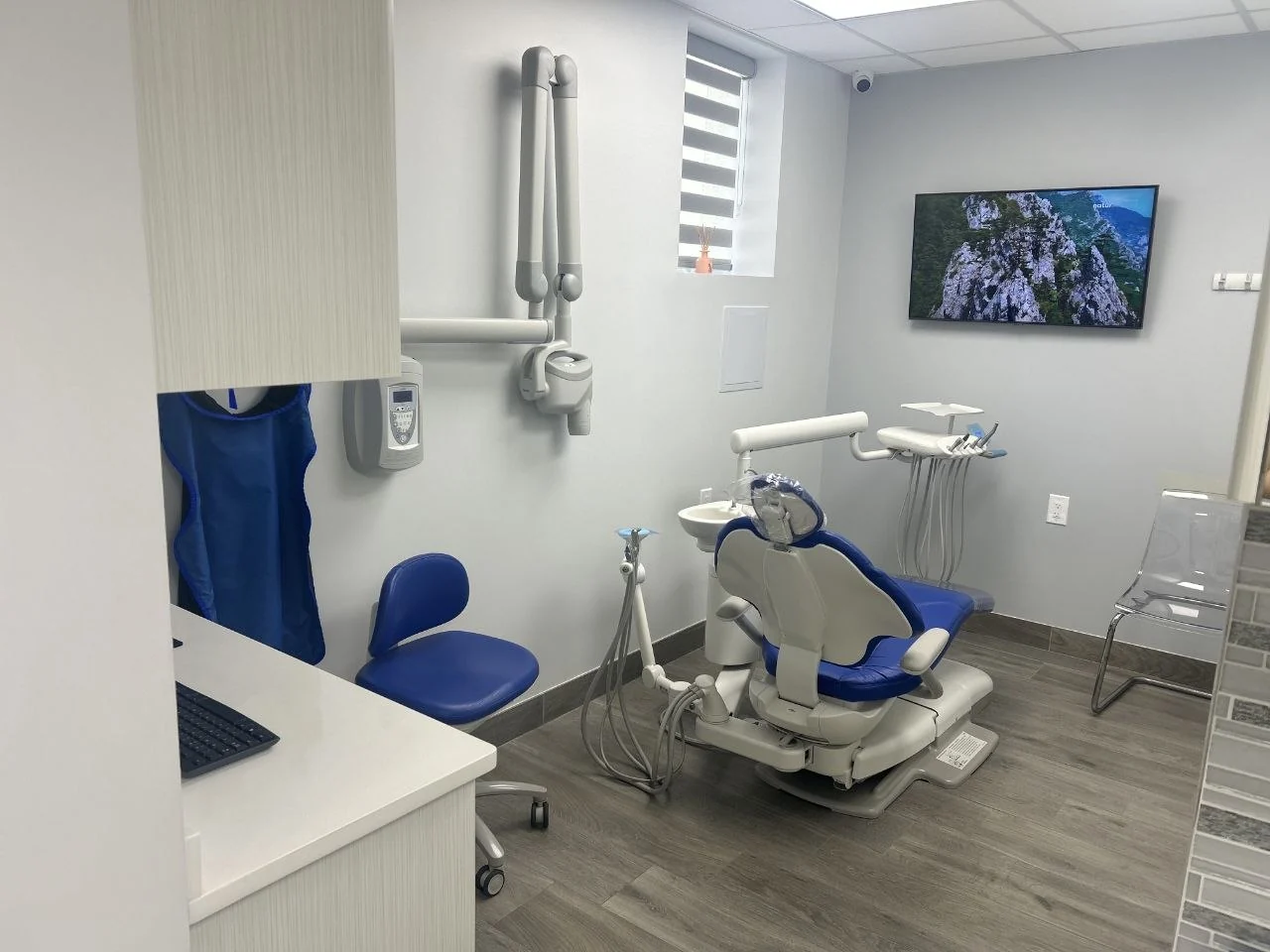Treatment room at BP Smiles Orthodontics with an orthodontic chair, wall-mounted X-ray arm, and a ceiling-mounted screen for patients.