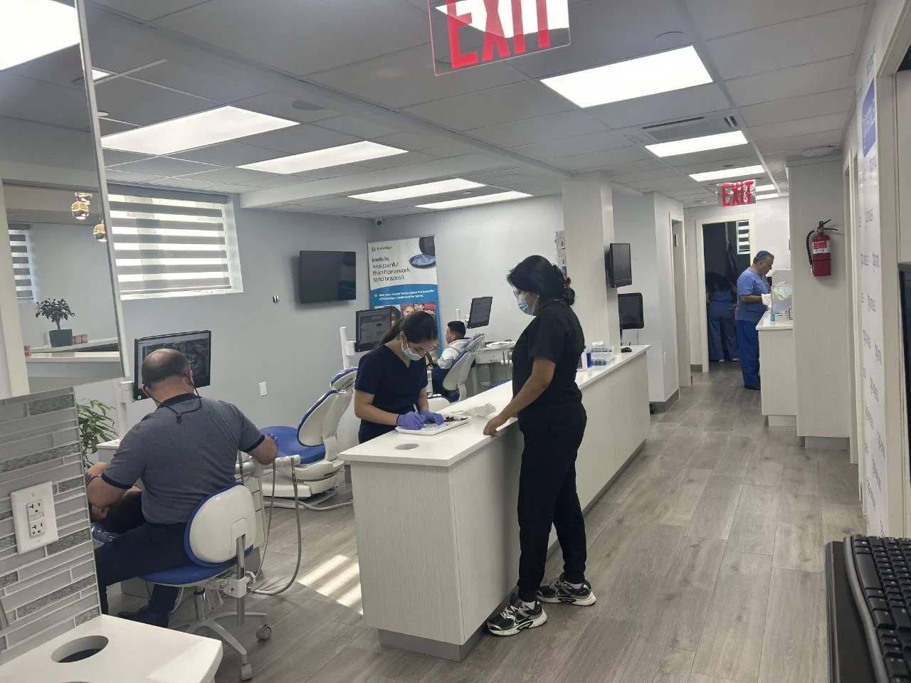 The clinical team treating patients in the open treatment bay at BP Smiles Orthodontics in Queens.